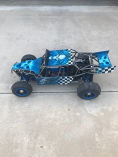 a blue and black toy car sitting on top of cement