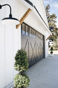 a large garage with a lamp on the side of it and a planter in front