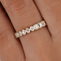 a woman's hand with a diamond ring on top of her finger and the band is