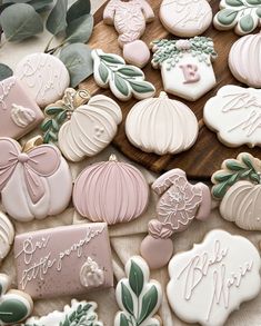 some decorated cookies are on a table with leaves and other things to eat in the background