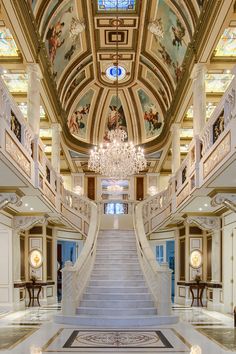 an ornate staircase leads up to the second floor in this large, elaborately decorated building