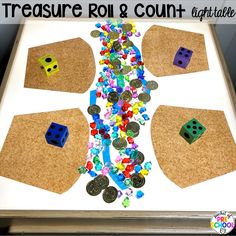 a cork board with dices, coins and other items to make a treasure roll and count game