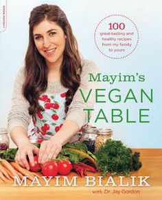 a cookbook with a woman cutting vegetables on the cover and text that reads, mayom's vegan table