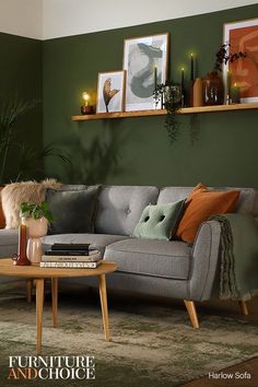 a living room with green walls and furniture in the corner, including a gray couch