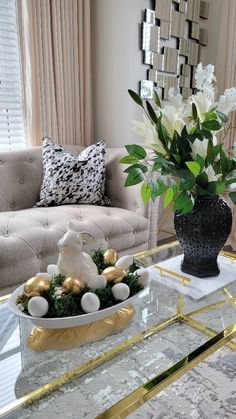 a glass coffee table with flowers and ornaments on it