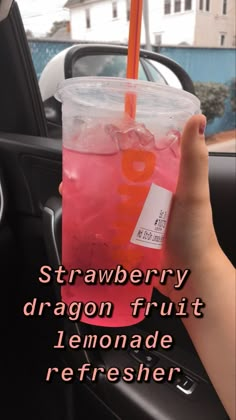 a person holding a drink in their hand with the words strawberry dragon fruit lemonade refresher