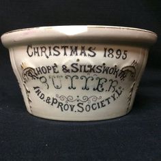 a white bowl with black writing on it and christmas decorations in the bottom half of it