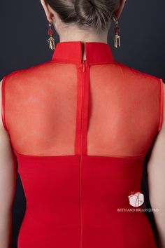 the back of a woman's red dress, with her hair in a bun