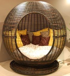 a wicker bed with pillows in the shape of a ball