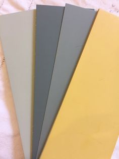 four different colors of paper sitting next to each other on a white sheeted surface