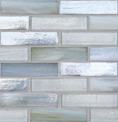 a close up view of a white and gray brick wall with silver foil on it