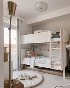 a bedroom with two bunk beds and a rug on the floor in front of it