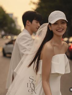 a man and woman walking down the street in wedding attire with veil over their heads