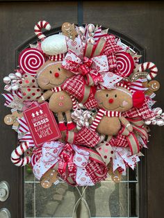 a christmas wreath with gingerbreads, candy canes and candies on the front door