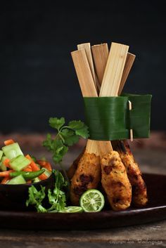 some food is on a plate with chopsticks and garnishes next to it