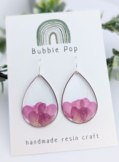 pink flowers are in tear shaped glass earrings