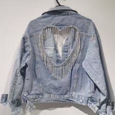 Not your basic jean jacket! Our Madelyn Jean Jacket features a Rhinestone Tassel Heart design on the back. making it one of a kind piece! It can be worn with a pair of heels and white jeans for brunch with girls or kept casual but chic with sandals or tennis shoes.