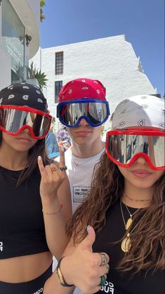 three people wearing goggles and pointing at the camera