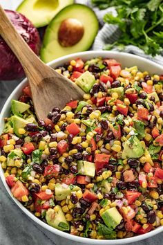 corn salad with avocado and tomatoes in a white bowl