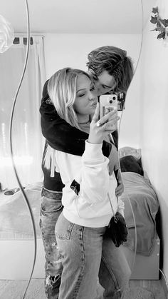 black and white photograph of two women taking a selfie in front of a mirror