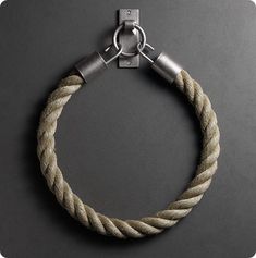 a rope bracelet with metal clasps on a black surface