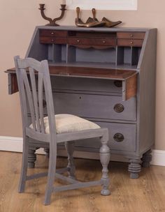 an old desk with a chair next to it