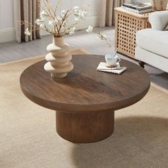 a living room with a couch, coffee table and vase on the carpeted floor