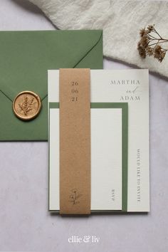 the wedding stationery is laid out on top of an envelope and wax stamper