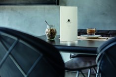 a table with two chairs and a drink in a glass on top of the table