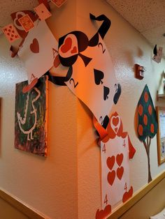 the wall is decorated with playing cards and other art work on it's sides