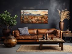 a living room with leather couches and potted plants on the table in front of it