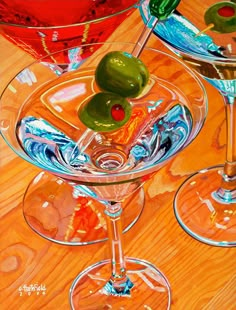 two martinis with green olives and red wine