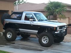 a black and silver truck parked in front of a house