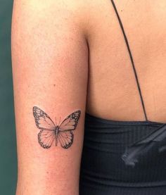 a woman's arm with a butterfly tattoo on the back of her left arm