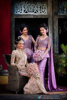 three beautiful women in purple dresses posing for a photo with flowers on their bouquets