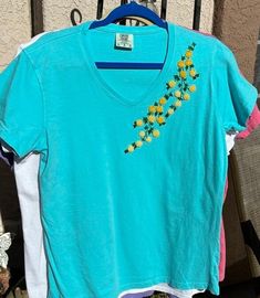 Hand embroidered  Charming flowers in shades of yellow cascade across the front of a Comfort Colors 100% cotton ladies V-neck t-shirt. Embroidered Tshirt, Shades Of Yellow, Lady V, Floral Shirt, Comfort Colors, Hand Embroidered, V Neck T Shirt, Fort, Gender Neutral