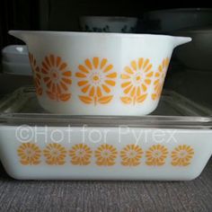 two white and orange dishes sitting on top of each other in front of a microwave