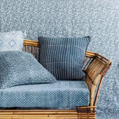 a bed with blue and white pillows on top of it next to a wooden frame