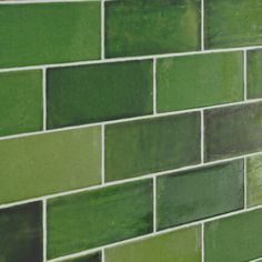 a green tiled wall in a bathroom