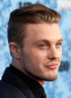 a close up of a person wearing a suit and tie on the red carpet at an event