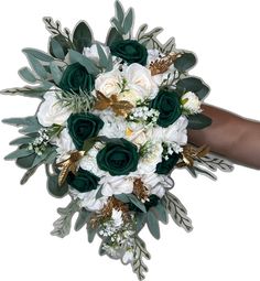 a bridal bouquet with white flowers and green leaves is being held by a woman's hand