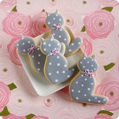 three decorated cookies sitting on top of a pink and white plate covered in icing