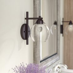 a bathroom sink with a mirror above it and a vase on the counter next to it