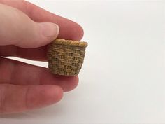 a hand holding a small ring made out of woven material