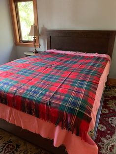 a bed with a plaid blanket on top of it