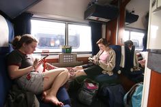 two women sitting on a train next to each other