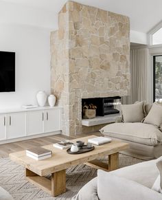 a living room filled with furniture and a stone fireplace