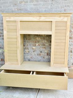 an unfinished fireplace surround made out of plywood and wood with two drawers on each side