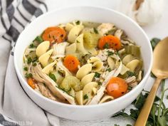 a white bowl filled with chicken noodle soup