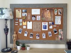 a bulletin board with pictures and photos hanging on the pegs next to a lamp